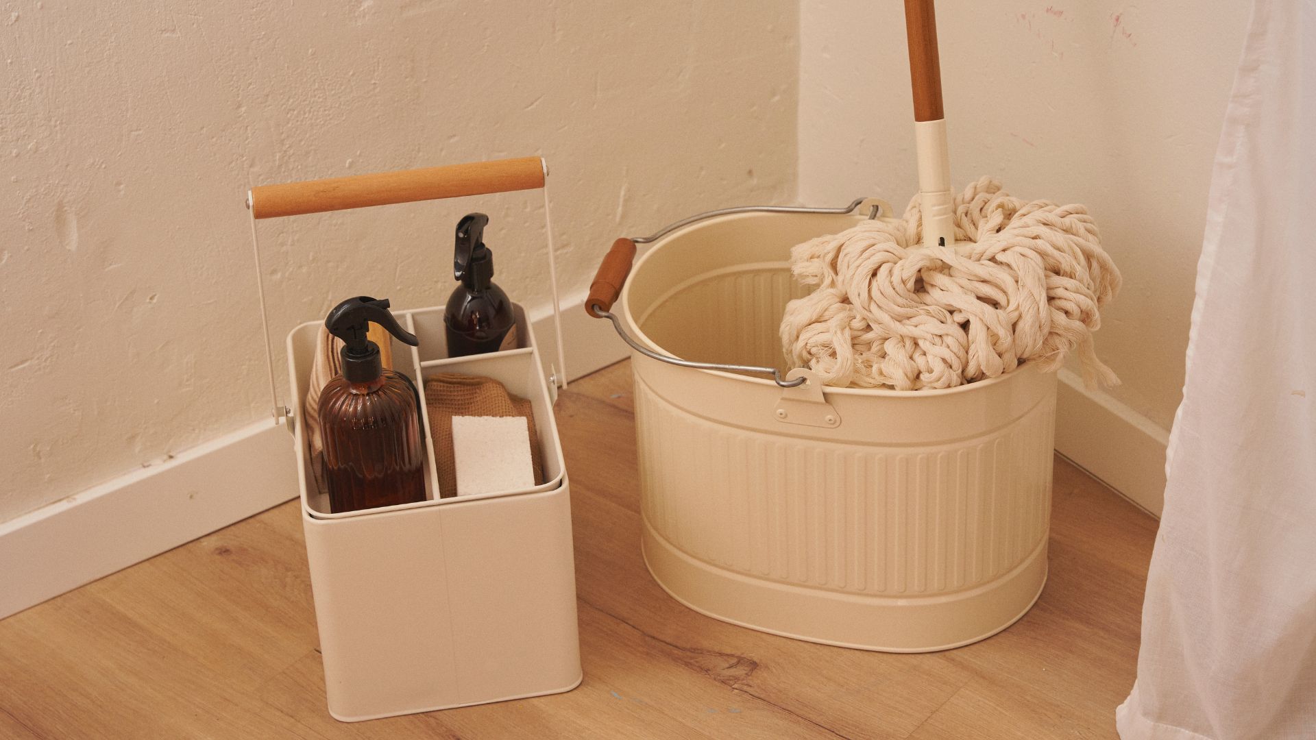 Cleaning supplies in neutral-toned containers with mop and spray bottles